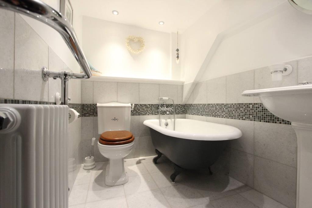 Lot: 65 - WELL-PRESENTED TWO-BEDROOM HOUSE - Bathroom with roll top bath